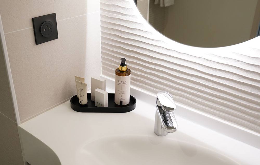 Salle de bain moderne avec produits d’accueil dans une chambre d’hôtel à Périgueux